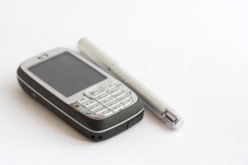 A cell phone and pen on white background