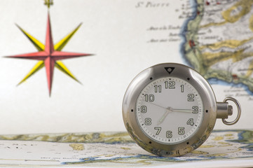 Silver pocket watch on an old map