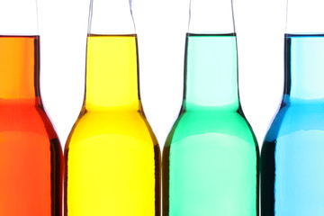 glass bottles with red, yellow, green, and blue liquid isolated