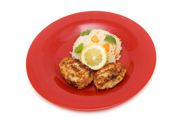 Cutlets, rice and lemon on the plate isolated