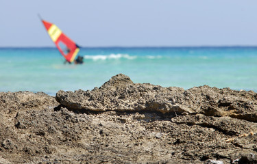 Fototapeta na wymiar Rocks with sea and windsurf - background blur to write your text