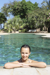 beautiful brunette caucasian relaxing in a swimming pool