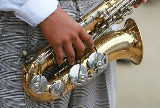 Marching with a saxaphone, a young man celebrates
