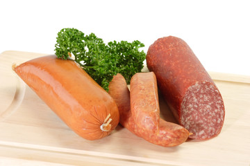 Wurstwaren auf einem Kuechenbrett auf weissem Hintergrund
