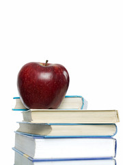 Red apple and stack of books for school.