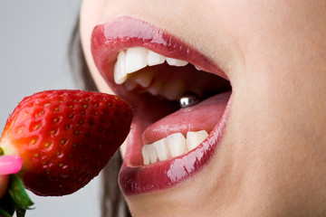 Mund beisst in Erdbeere - Zunge mit Piercing