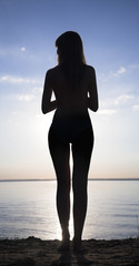 Fototapeta premium silhouette of young woman against summer sunset