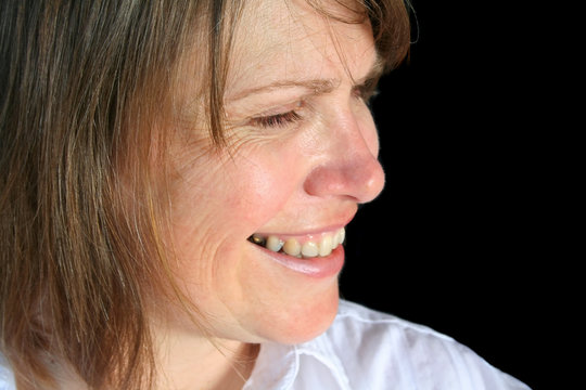 Profile close up of a middle aged female smiling.