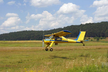 Fototapeta na wymiar Yellow plane taking off
