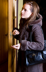 woman is standing in doorway with key in palm