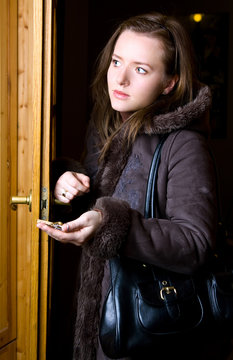 woman is standing in doorway with key in palm