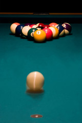 White ball is rolling to break the racked billiard balls