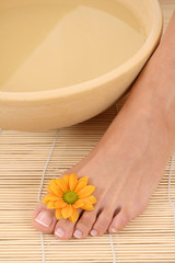 Obraz na płótnie Canvas beautiful leg - beauty treatment - bowl of pure water
