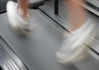 Close-up of man's feet running on treadmill