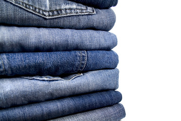stack of blue jeans over white