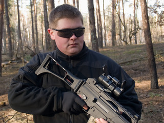 The man in protective goggles holding the rifle
