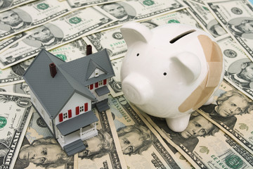 Piggy bank with adhesive bandage and house