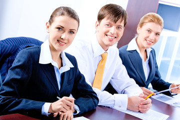 Row of three successful business people looking at camera