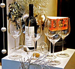 Photo of the tall wineglasses situated on window shop..