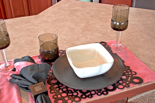 A place setting with a bowl, plate, and glasses.