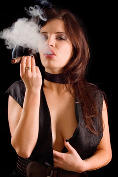 Beautiful woman smoking a cigar and blowing smoke