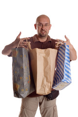 Young man with eyeglasses holding paper bags after shopping