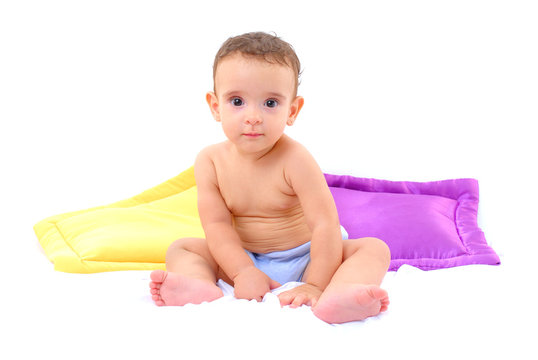 Photo of a baby and two pillows on white .