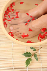 Obraz na płótnie Canvas relaxing bath with flower petals - beauty treatment