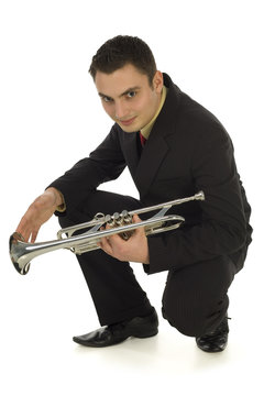 Man In Suit Holding A Trumpet And Crouching.