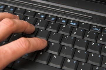 fingers on notebook keyboard