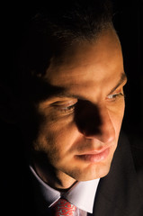 Obraz premium Portrait of a young businessman under dramatic lighting