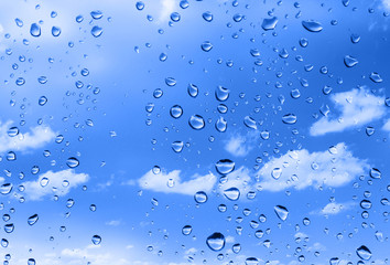 water drops against bright summer sky with cumulus clouds