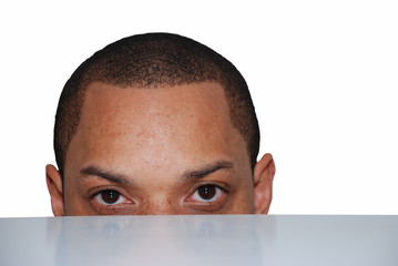 portrait d'homme se cachant derrire une table