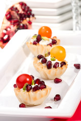 fillo shells filled with cream cheese, Pomegranates, tomatoes