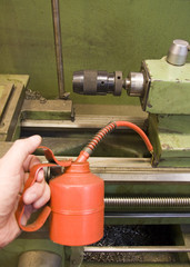 Using an oil can to lubricate an old metal lathe