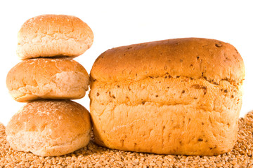 Three rolls and loaf on bed of wheat