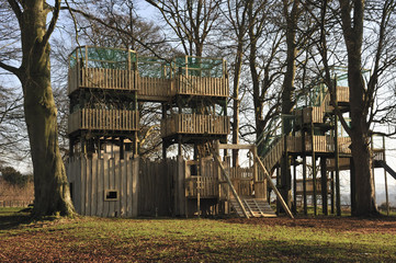 An adventure playground made from wood with walkways.
