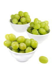 Green Grapes in small white bowls isolated on white background.