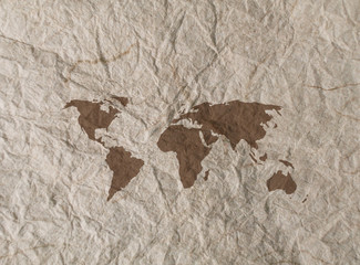 World outline map overlaid onto rumpled textured paper