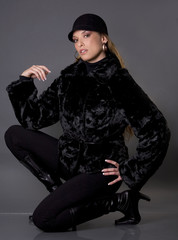 pretty model wearing black fur coat and black pants