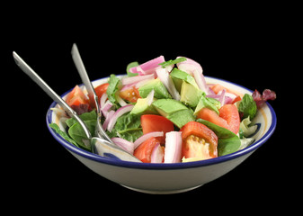 Freshly prepared garden salad with spoon and fork.