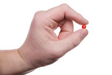 hand holds a red pill. Isolated on white [with clipping path].