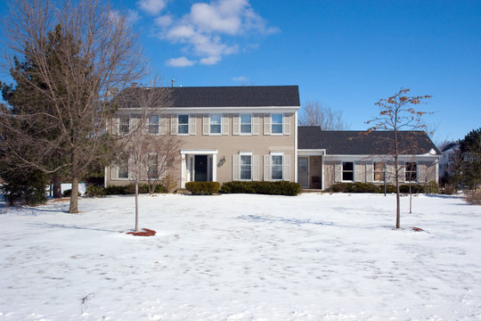 Colonial House With Snow In The Front Yard