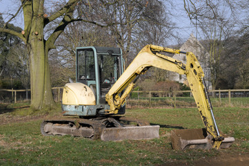 digger in countryside digging holes in the ground