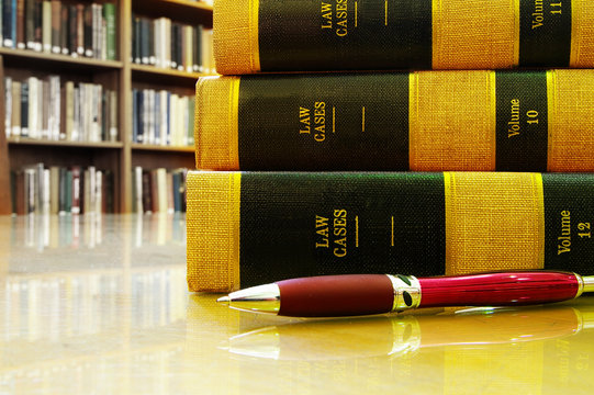 Lawbooks and a pen on a table,  in a library