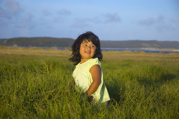 Happy cute little girl on the summer meadow in the evening