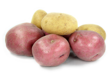 Tubers of red and yellow potatoes over white background.