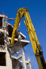 Destruction of concrete wall of old building with excavators