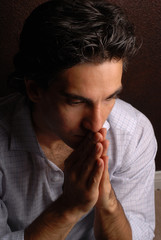 a sad man praying for his problems to be resolved