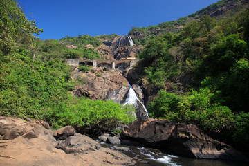 Train crossing the bridge at Dudhsagar Falls Goa India.